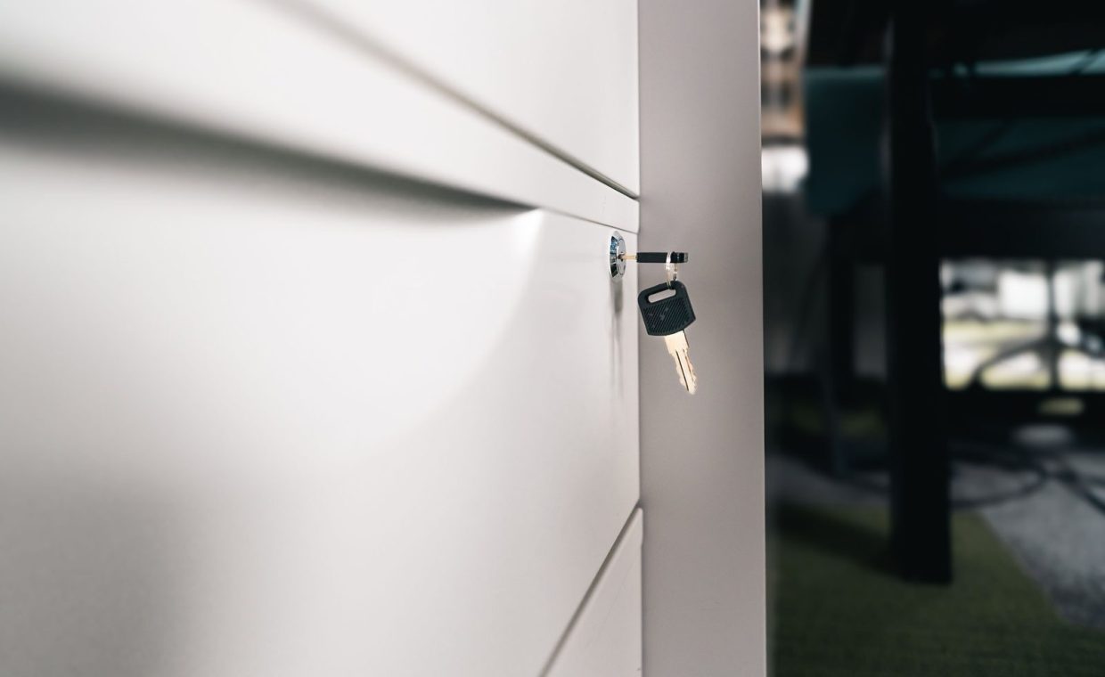 Close-up of a key in a locked office drawer for secure storage and privacy.