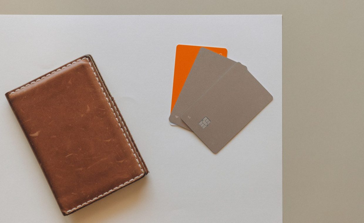 A leather wallet and credit cards on a minimalist background, ideal for financial themes.