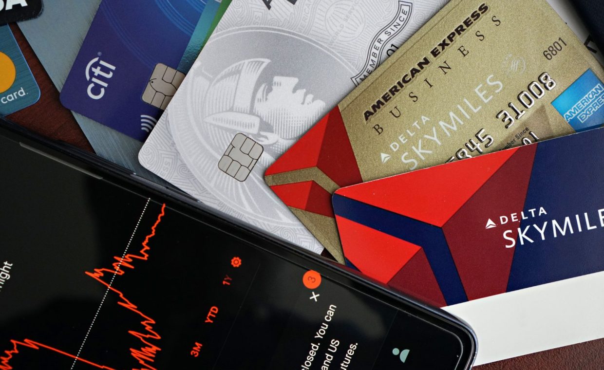Image showing credit cards and a financial market graph on a smartphone.