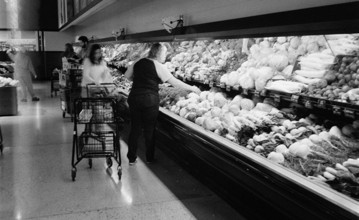 People shopping for produce in a grocery store.