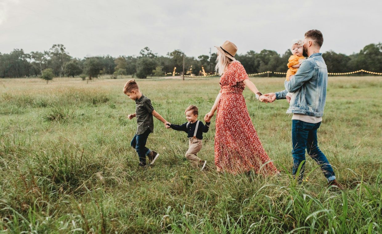 woman holding man and toddler hands during daytime