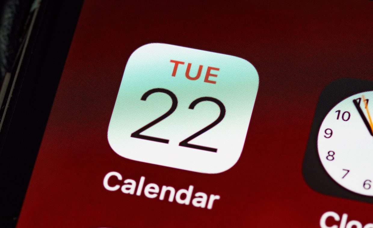 Detailed close-up of an iPhone home screen focused on the calendar app icon.