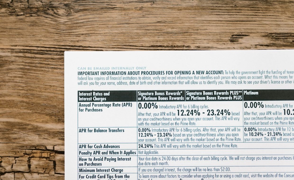 A detailed financial document listing interest rates on a textured wooden table.