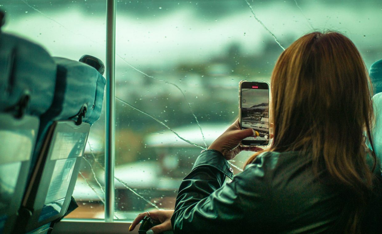 a woman taking a picture of a broken window
