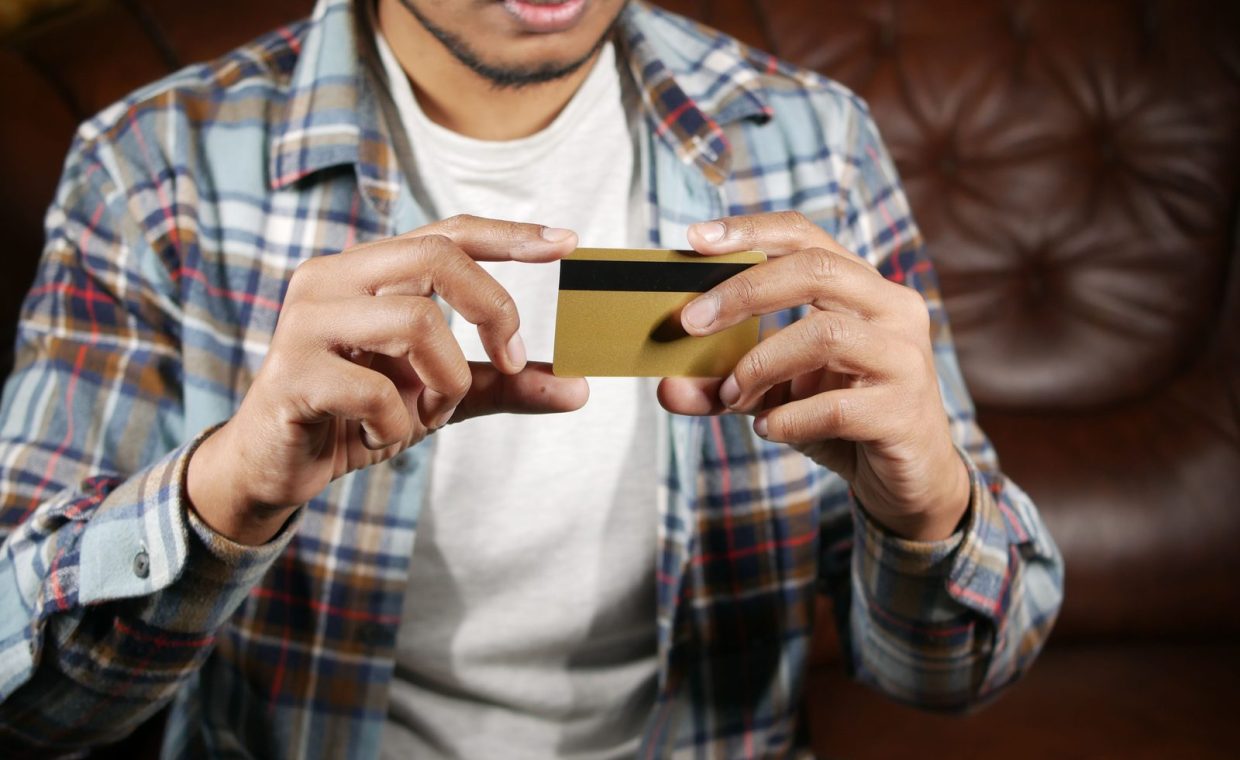 Person holding a credit card, focusing on hands and card for financial themes.