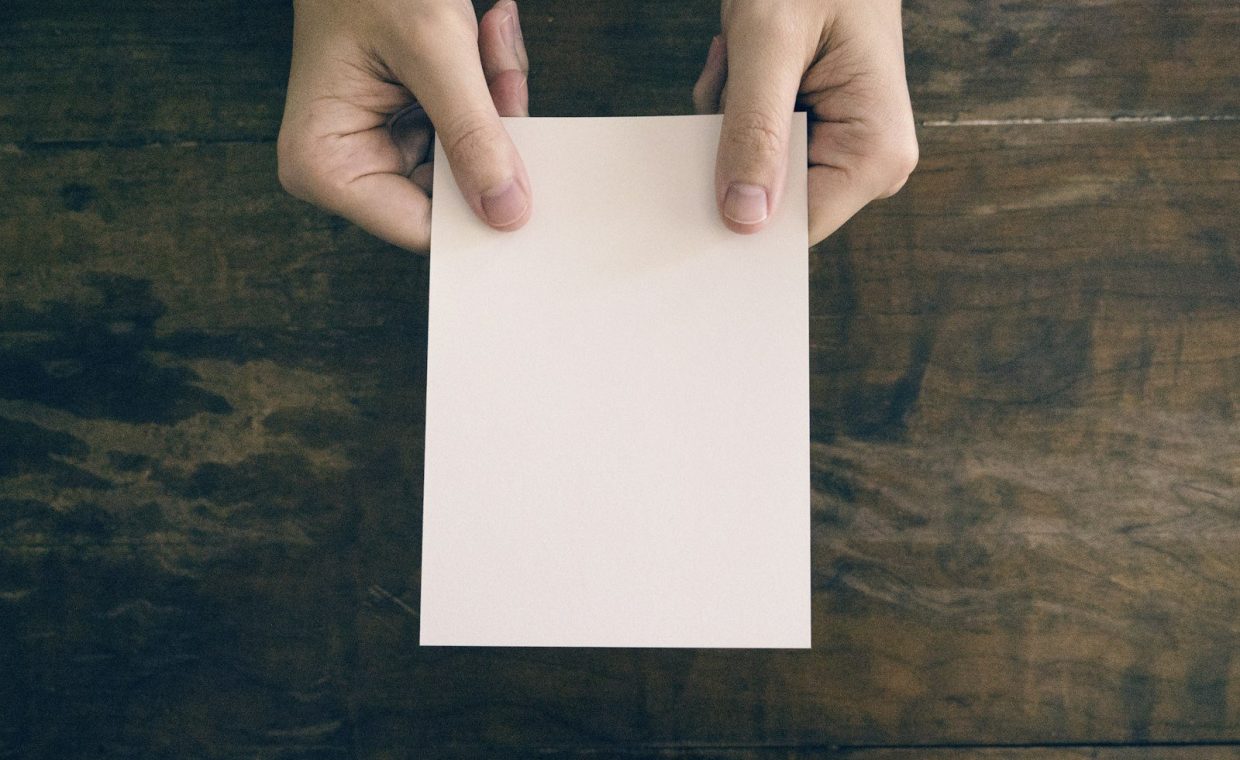 person holding white printer paper